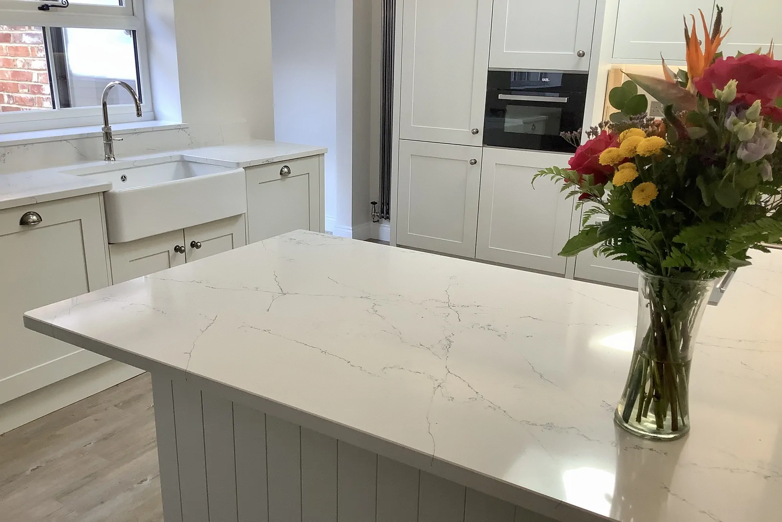 Shaker kitchen in Highland Grey with butler sink and Pietra Icy White worktops by Redwood Kitchens