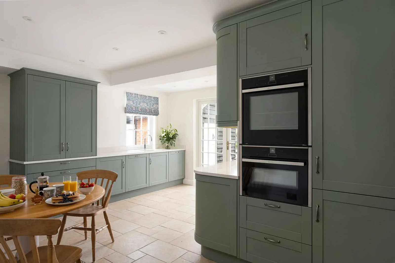 Reed green shaker kitchen with Neff oven & microwave, undermount sink with Quooker tap, and quartz worktops in a bright Binfield home by Redwood Kitchens, Wokingham