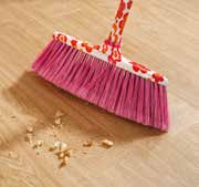 Soft brush sweeping crumbs from a wood-effect LVT floor